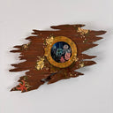 Sculpture made of wood of a ripped part of a ship, left only with a circular window and many barnacles on the side of the wood. Inside the window are small jellyfish and coral, behind cracked glass.