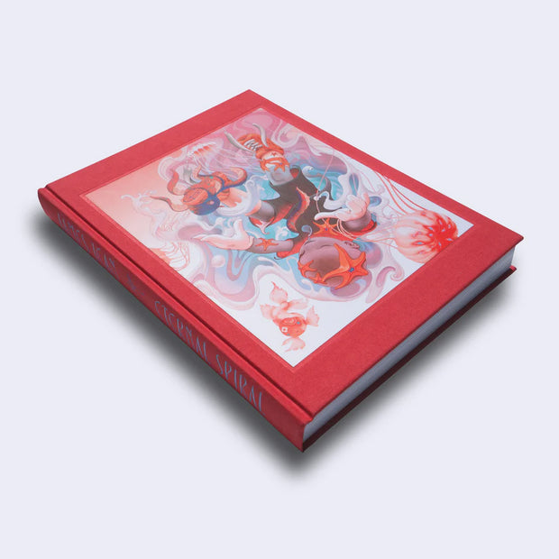 Coral colored hardcover book, with an illustration from James Jean on the front of an upside down boy submerged under water with starfish and jellyfish adorning him.