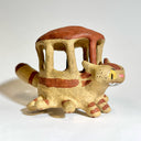 Ceramic sculpture resembling the Catbus from My Neighbor Totoro, with a house-like structure on its back against a white background