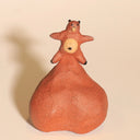 Ceramic sculpture of a tanuki - a raccoon creature - with a comically large ball sack, inflated to act as a base for him.