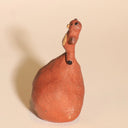 Ceramic sculpture of a tanuki - a raccoon creature - with a comically large ball sack, inflated to act as a base for him.