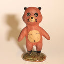Small ceramic sculpture of a tanuki - a raccoon creature standing on a glazed ceramic platform.
