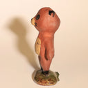 Small ceramic sculpture of a tanuki - a raccoon creature standing on a glazed ceramic platform.