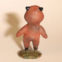 Small ceramic sculpture of a tanuki - a raccoon creature standing on a glazed ceramic platform.