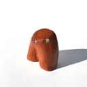 Brown ceramic sculpture of an abstract dog with a tiny face on a white background