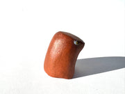Brown ceramic sculpture of an abstract dog with a tiny face on a white background