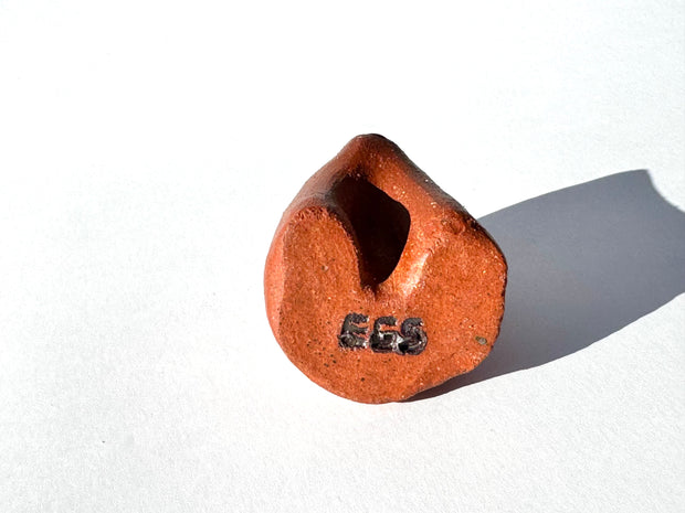 Brown ceramic sculpture of an abstract dog with a tiny face on a white background