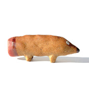 Ceramic sculpture of a brown dog made to look like a pencil, with a pointed tip black nose and a pink eraser shaped butt. It has several holes atop its back to hold pens.