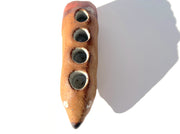 Ceramic sculpture of a brown dog made to look like a pencil, with a pointed tip black nose and a pink eraser shaped butt. It has several holes atop its back to hold pens.