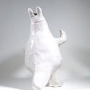 Ceramic sculpture of Moomin, posed like Frankenstein with its arms up and a line running across its head.