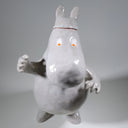 Ceramic sculpture of Moomin, posed like Frankenstein with its arms up and a line running across its head.