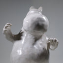 Ceramic sculpture of Moomin, posed like Frankenstein with its arms up and a line running across its head.