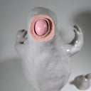 Ceramic sculpture of Moomin, posed like Frankenstein with its arms up and a line running across its head.