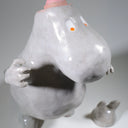 Ceramic sculpture of Moomin, posed like Frankenstein with its arms up and a line running across its head.