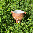 Small ceramic animal figure of a cat or brown tiger or sorts, with a cup as its head.