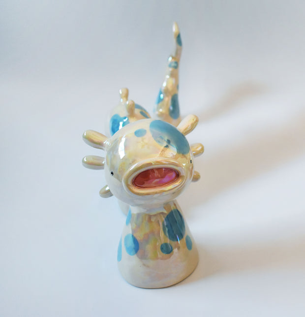 Set of ceramic sculpture, 3 pieces, making up a sea monster made to look partially submerged in water. It has a wide, open mouth, spots on its body and rounded spikes on its back.