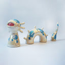 Set of ceramic sculpture, 3 pieces, making up a sea monster made to look partially submerged in water. It has a wide, open mouth, spots on its body and rounded spikes on its back.