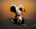 Lamp designed as a cow's body sitting on the ground, with 2 light bulbs coming from 2 separate cow heads conjoined to the same neck.