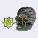 Illustration made with many lines, giving it the feel of a folk art woodcut on a die cut wood panel of a large head, faced to the left with a scene inside of it of a orange rabbit creature standing within a smaller head and exclaiming a pattern.