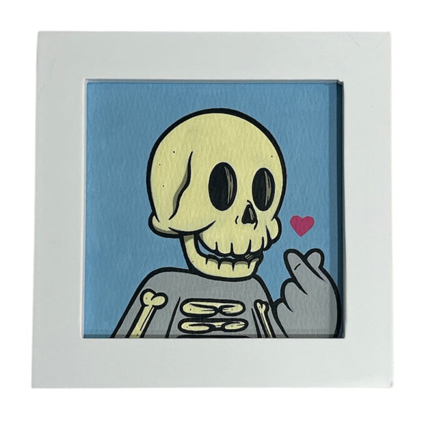 Framed artwork of a skeleton with a heart on a blue background