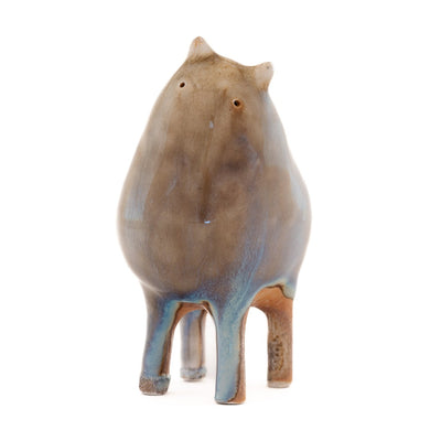 Ceramic sculpture of a brown character with a rounded body, small ears and eyes and skinny legs and no other body features.