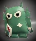 Sage green vinyl fabric plush of a Big Boss Robot, slightly shorter and with large eyes. It holds a small white magazine with a red and a blue robot on it.