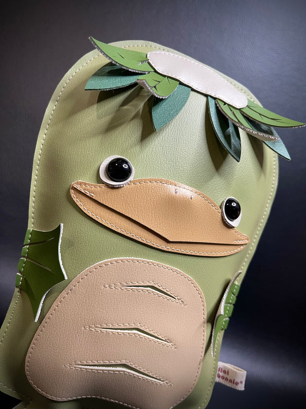  Vinyl plush sculpture of a green kappa, with leaves coming off the top of its head and a beak. It has fins for hands.
