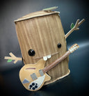 Vinyl fabric plush of a tree stump, with different sized shiny eyes and a buck tooth smile. It has its branch arms extended out in excitement and has a guitar around its body.