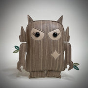 Vinyl art plush of a semi flat doll - a chibi version of a Big Boss Robot with wood like fabric. It has cute angry eyes and small leaves growing off of its arms.