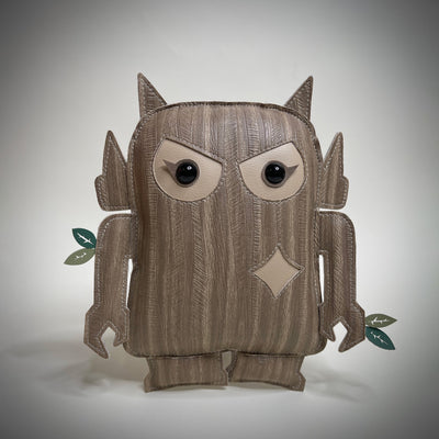Vinyl art plush of a semi flat doll - a chibi version of a Big Boss Robot with wood like fabric. It has cute angry eyes and small leaves growing off of its arms.