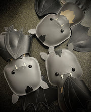 3 vinyl plushes of a cartoon style bat with small fangs their wings in different positions.