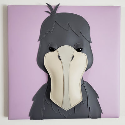  Vinyl fabric sculpture of a cartoon style shoebill bird, looking straight on so its beak looks flat on a lilac colored square canvas.