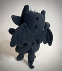 Black plush dragon toy on a white background