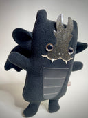 Black plush toy with silver accents on a white background