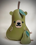 Vinyl plush flat sculpture of a pear with a bear face, small bear ears and small clawed hands. At its side is a smaller pear plush, without any facial features.