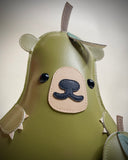 Vinyl plush flat sculpture of a pear with a bear face, small bear ears and small clawed hands. At its side is a smaller pear plush, without any facial features.