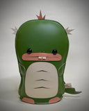 Vinyl fabric plush of a flat dinosaur/kaiju monster with a wide mouth and 2 buckteeth.