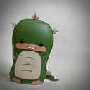 Vinyl fabric plush of a flat dinosaur/kaiju monster with a wide mouth and 2 buckteeth.