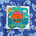 Colorful painting of an orange character with a cute cartoon face, in a inflatable tube in water.