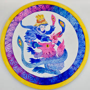 Bright blue and pink illustration on a circular panel with a yellow outline. A wolf creature is opens its mouth, a large blue snake creature comes out with a person's face.