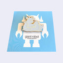 A gold and silver metallic pin shaped like a cute deer family sitting on a white robot figure, displayed on a blue backing card with the text 'giant robot' and 'sawtelle japantown'.