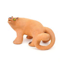 Ceramic figurine of a stylistic jaguar with yellow eyes.