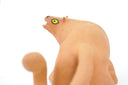 Ceramic figurine of a stylistic jaguar with yellow eyes.
