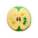 Flat backed sculpture of a green apple interior with small seeds and a tiny green worm coming out of it.