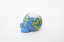 Ceramic sculpture of a blue planet with green floral dots, smiling and sitting next to a tiny moon.
