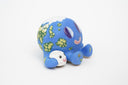 Ceramic sculpture of a blue planet with green floral dots, smiling and sitting next to a tiny moon.