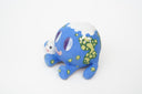 Ceramic sculpture of a blue planet with green floral dots, smiling and sitting next to a tiny moon.