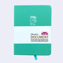 A teal green hardcover notebook with a white paper band around the middle. The band features the brand name 'DOCUMENT' and the tagline 'PLOTS DOTS AND MANIFESTOS' alongside a small pink robot logo.