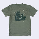 Green t-shirt with a graphic of a deer and baby deer under a moon and stars on a light gray background.