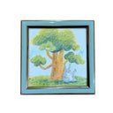 Framed artwork of a crayon illustration - Totoro sitting under a tree on a grassy hill with a blue sky.